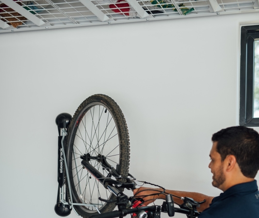 man hanging a bike on a bike rack